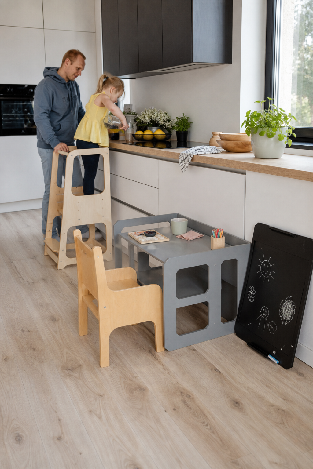 Parent and toddler cooking together with a Montessori learning tower in a bright kitchen
